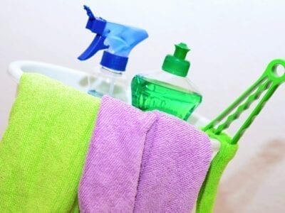 Cleaning bucket holding microfiber clothes and cleaning products.