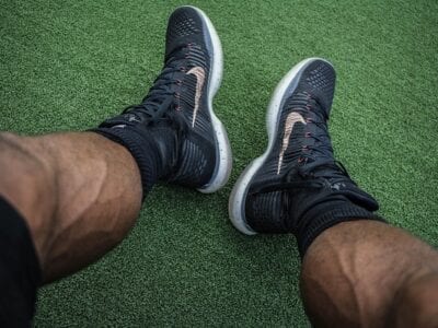 Close up photo of an athlete wearing black tennis shoes.
