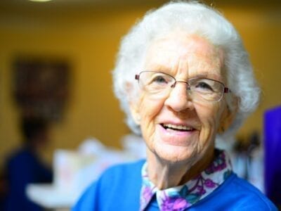 Close up photo of an elderly woman smiling.