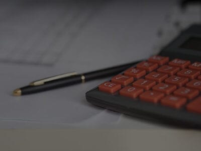 Photo of a calculator and pen.