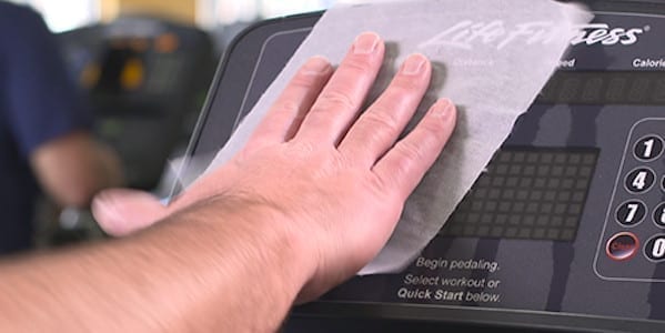 CleaningTech Hand wiping gym equipment.
