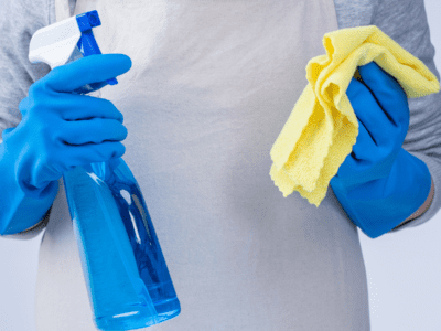 Person holding cleaning spray and wipe.